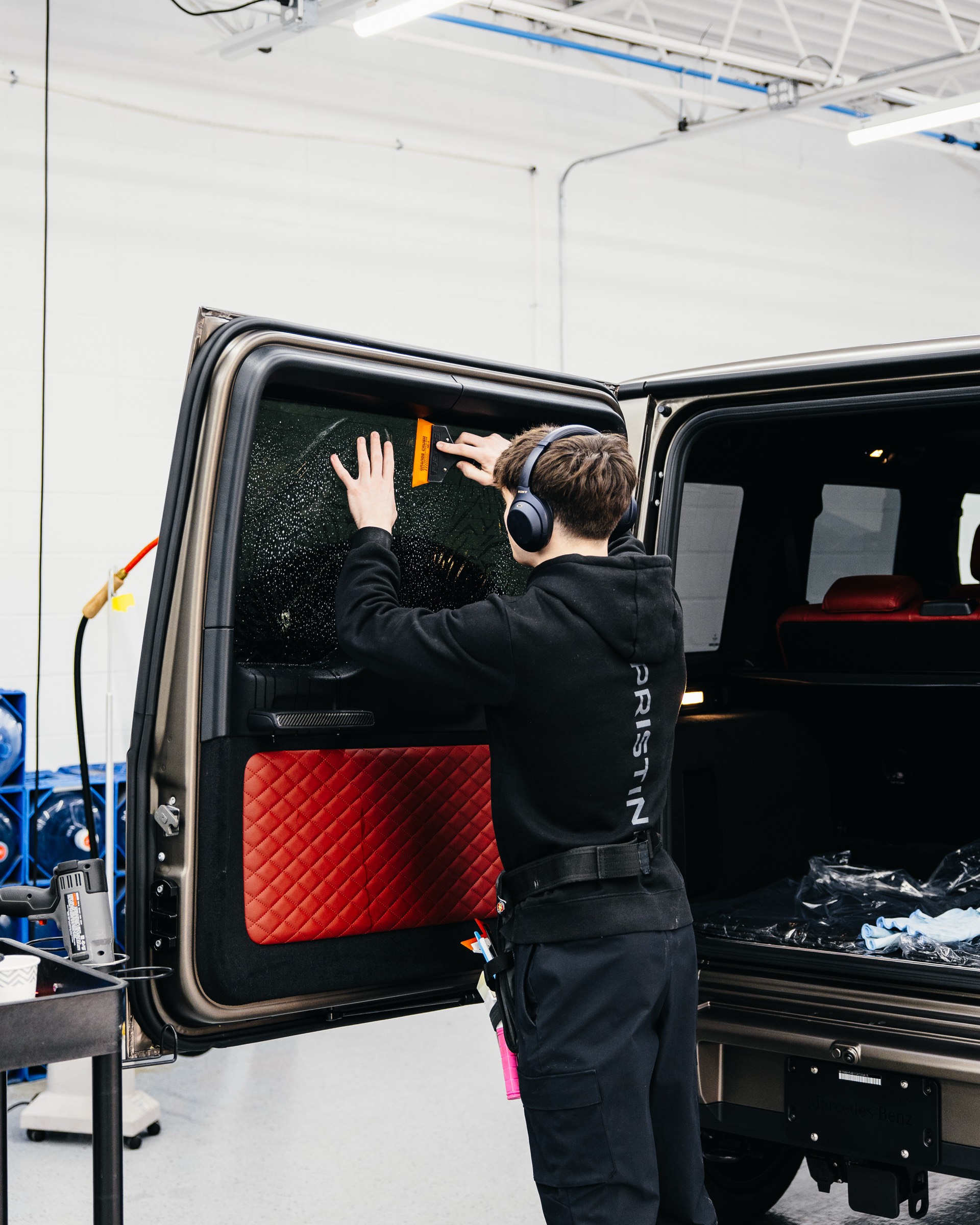 Technician installing tint on a G-Wagon at Pristine Film Solutions